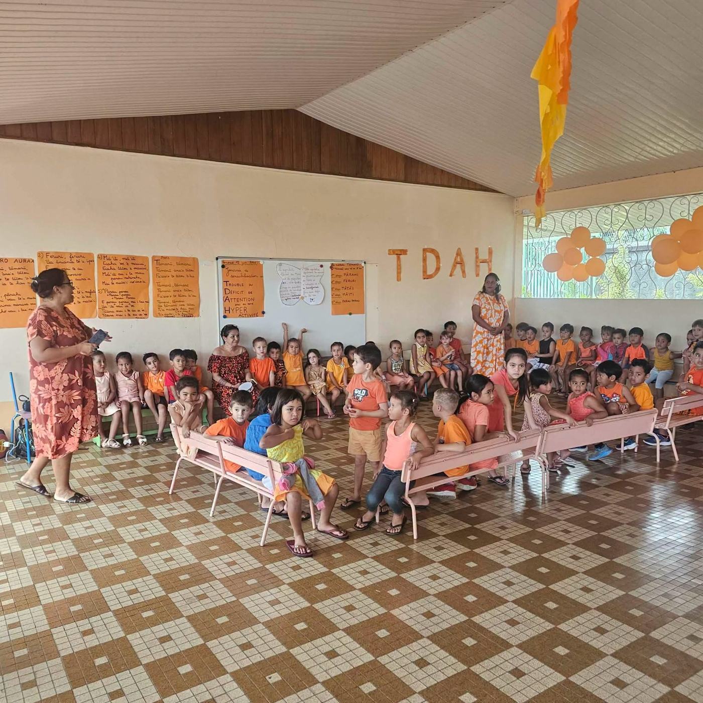 Les enfants de l'école maternelle de Heiri, habillés en orange, pendant la journée de sensibilisation