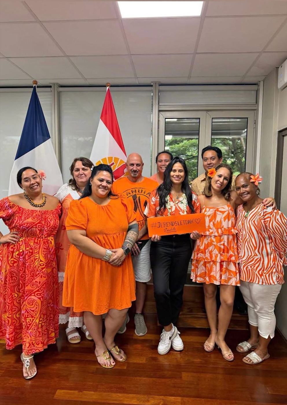 Une équipe institutionnelle en orange tenant la pancarte #JeRendsLeTDAHVisible