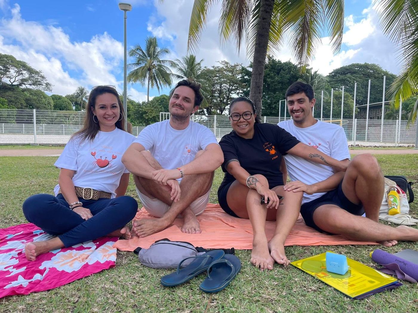 Membres de l'association en tee-shirts au crabe, assis sur l'herbe