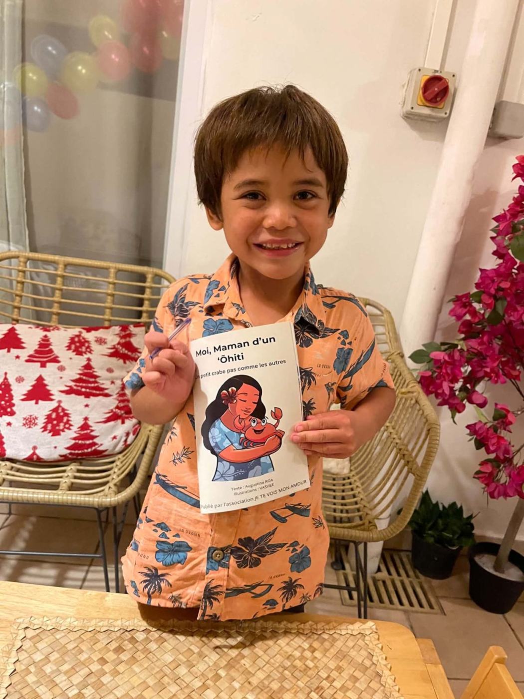 Un enfant souriant tient le livre
