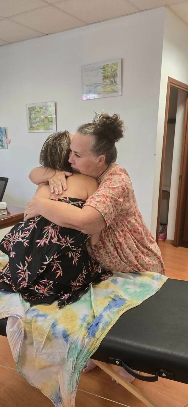 Une maman et son enfant dans les bras l'une de l'autre après le massage