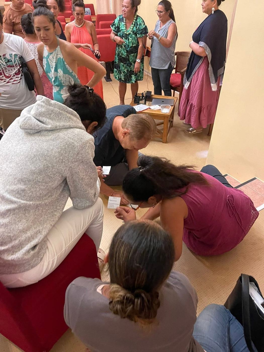 Enseignants penchés sur un exercice d'écriture au sol