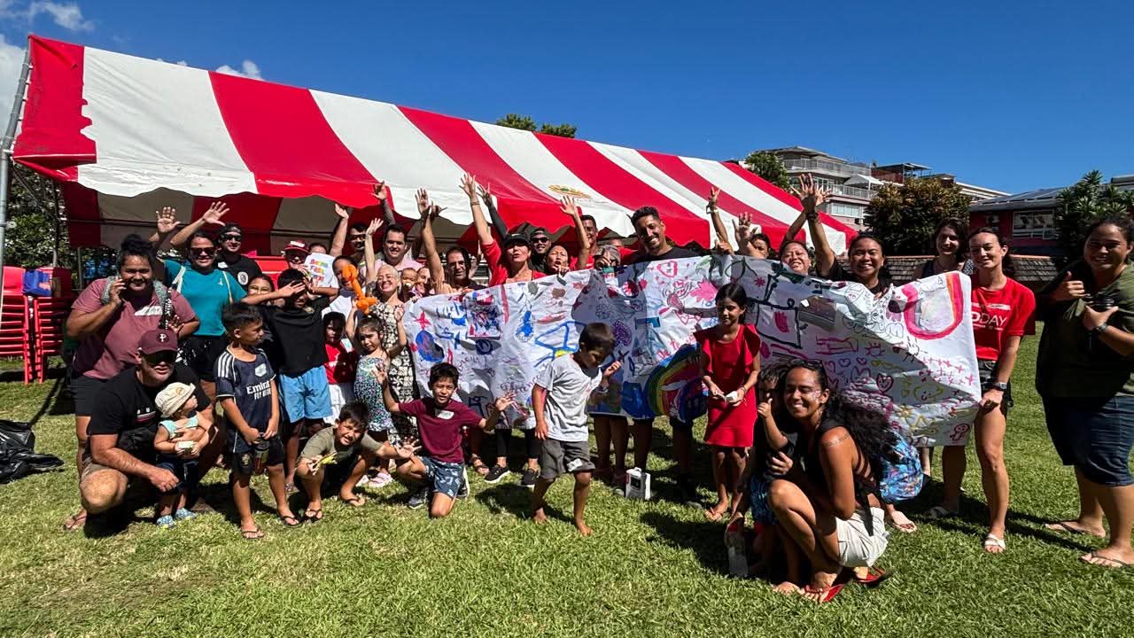 Un grand rassemblement de familles, d'enfants et de bénévoles de l'association, réunis autour d'une banderole collective